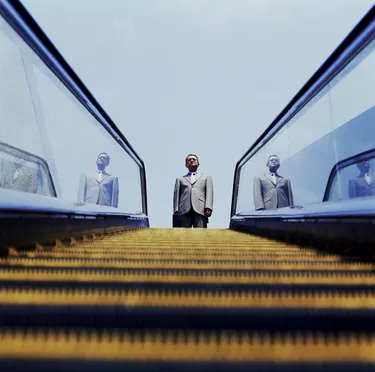 Businessman Looking Down Escalator