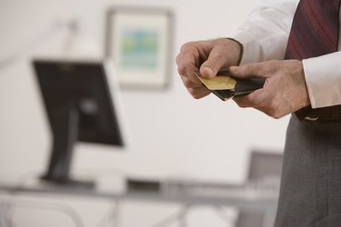 Hands taking credit card out of wallet