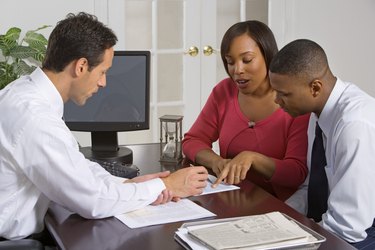 Businessman discussing paperwork with couple