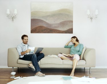 Couple Sits on Sofa Examing Their Bills