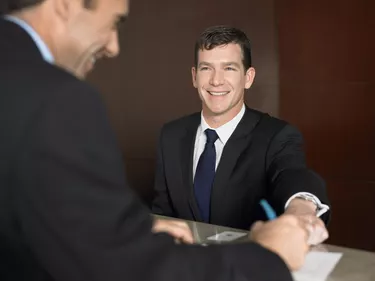 Businessman Signing a Document at a Reception Desk
