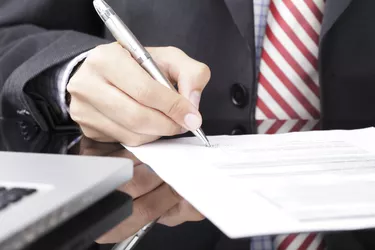 Businessman writing on a form