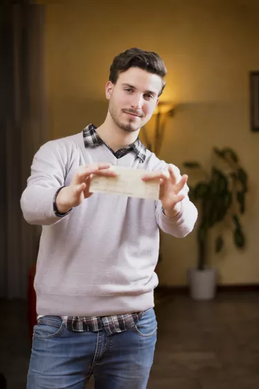 Handsome young man holding check in his hands