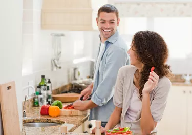 couple laughing and making dinner