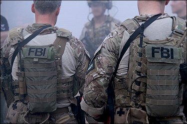 A back view of men in bulletproof FBI vests.