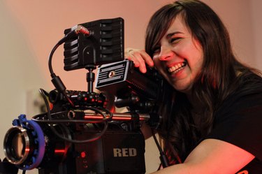 Smiling woman operating video recording equipment