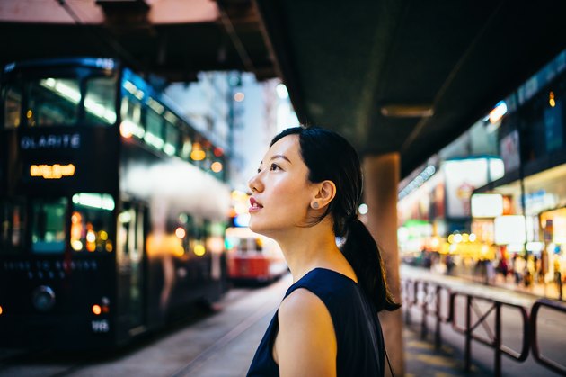 Young Asian woman traveller visiting and exploring busy city street in downtown Hong Kong