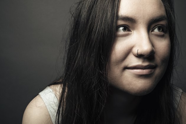 Close up portrait confident beautiful brunette teenage girl with nose ring