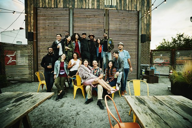 Friends posing for group photo during party at outdoor restaurant