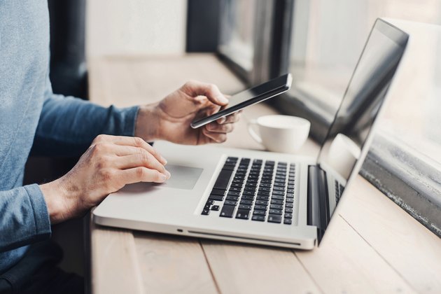 Young man using laptop computer and smart phone