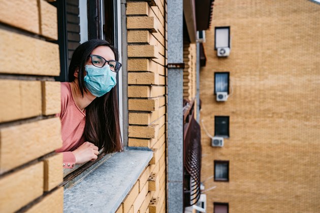Woman in quarantine looking through the window