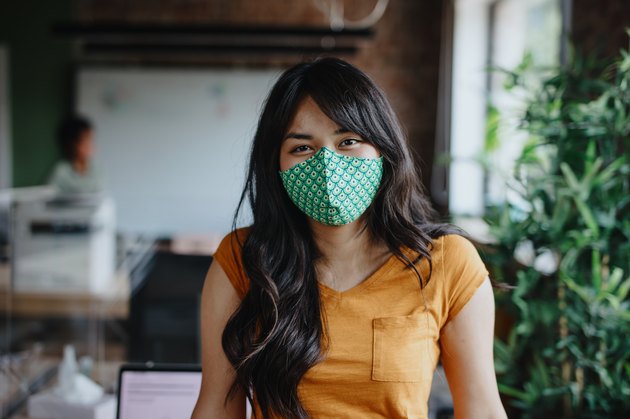 Portrait of businesswoman with cloth face mask after returning back to work