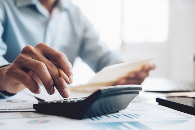 Male accountant or banker use calculator.