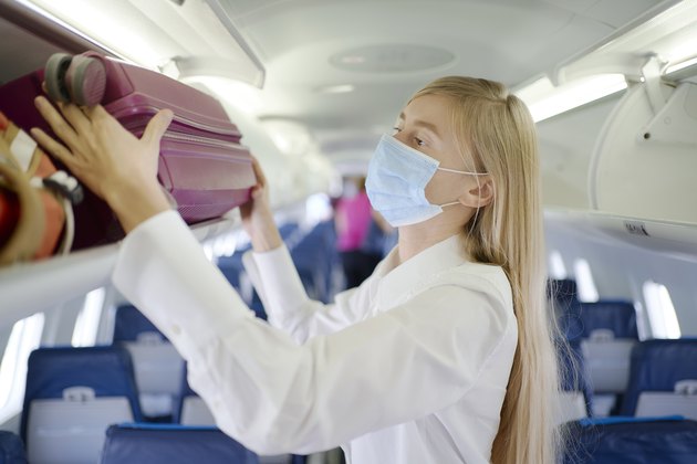 Woman wearing mask inside airplane