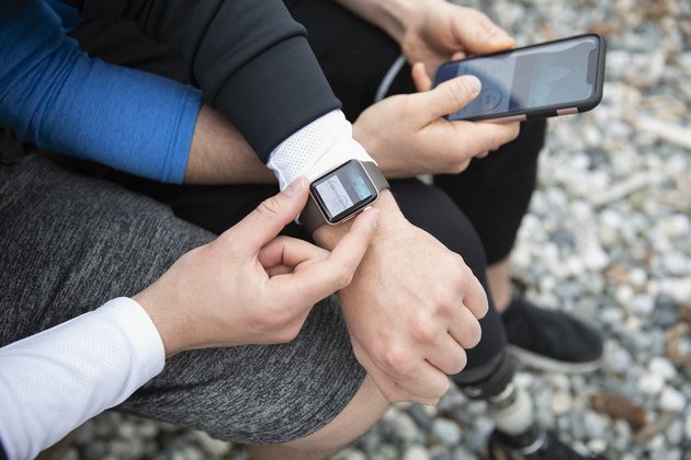 Overhead view gay couple preparing smart watch, checking fitness app on smart phone