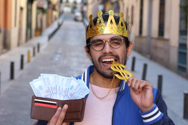 Crowned young guy with full wallet