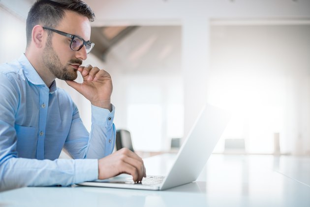 Portrait of young man sitting at his desk in the office