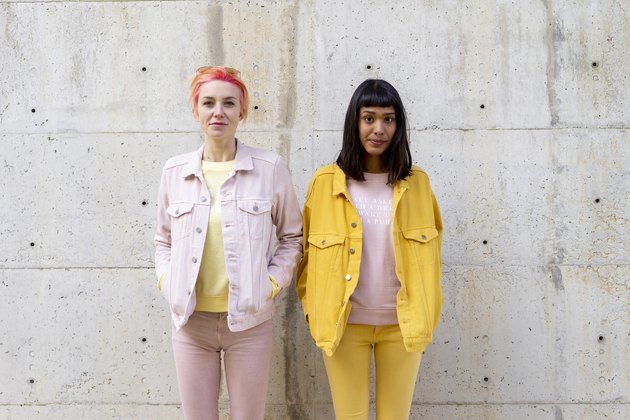 Two alternative friends having fun, wearing yellow and pink jeans clothes