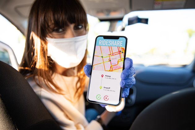 Car sharing driver showing destination to passengers on smart phone
