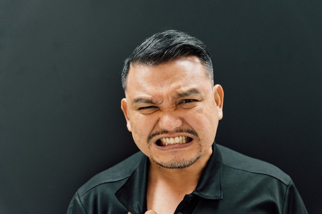 Portrait Of Angry Mature Man Against Black Background