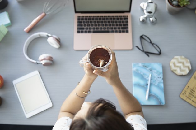 View from above businesswoman drinking tea at desk