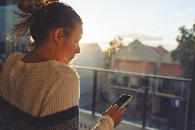 Woman looking through the window at sunset.