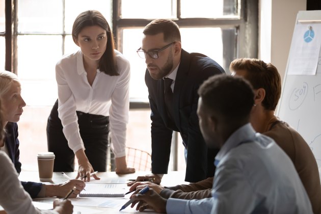 Successful young female team leader listening to coworkers ideas.