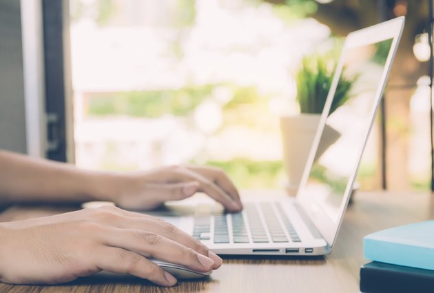Hand of business man working from home using laptop computer to internet online on desk, lifestyle of new normal, social distancing, freelance work in stay home, employee using notebook indoor.