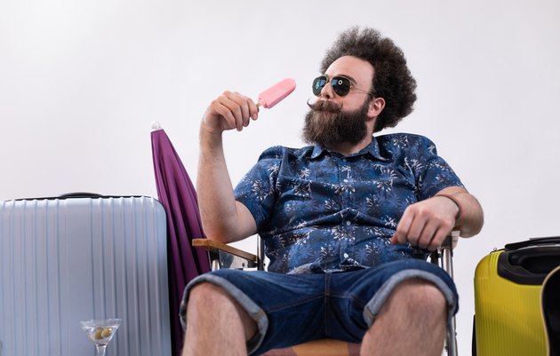 Handsome hipster adventurer enjoying some ice cream on his vacation