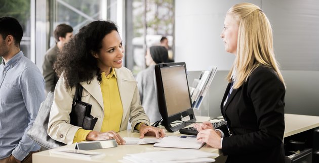 Female bank teller advising female customer