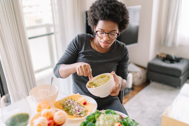 Young woman eating vegan food at home