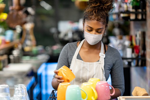 Waitress working at a cafe wearing a facemask during the COVID-19 pandemic