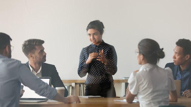 Female indian coach hold meeting brainstorming with employees
