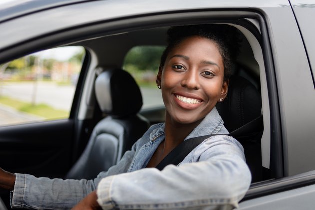 Portrait of young afro woman driving a car