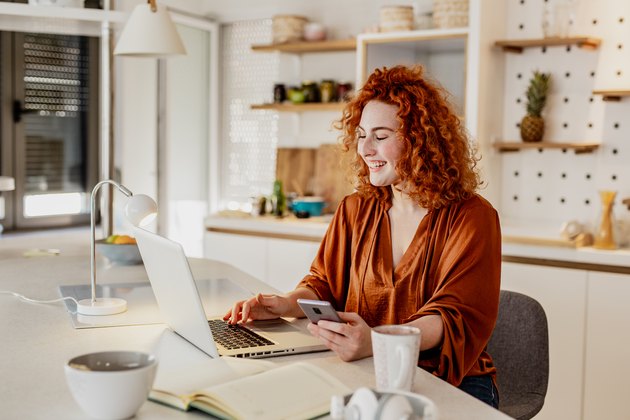 Young redhead woman is working from home