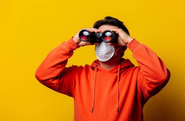 guy in face mask looking in to binoculars