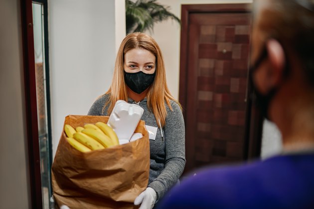 Volunteer Delivering Food To Elderly People During Lockdown