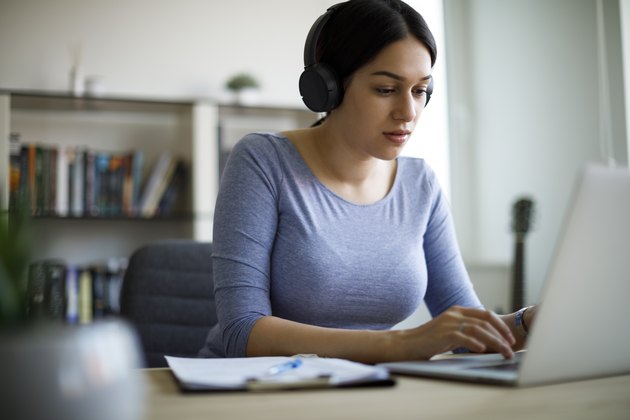 Young woman with headphones working from home
