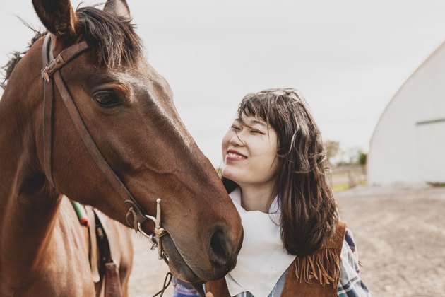 cute chinese cowgirl taking care of horse