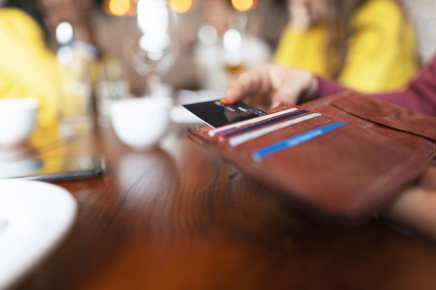 Hand pulling credit card from a wallet