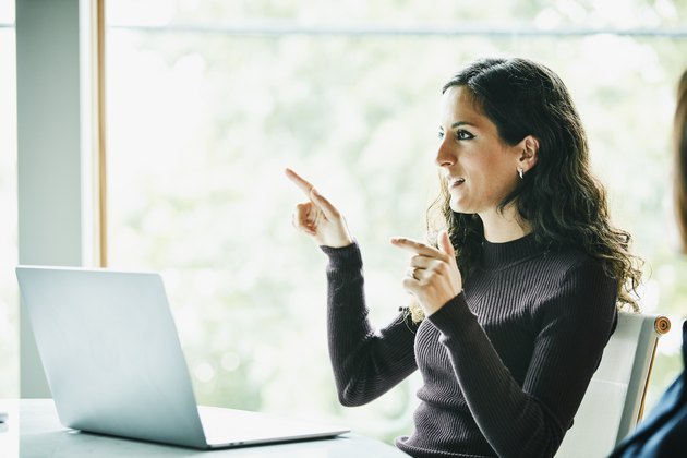Businesswoman explaining project details to colleagues during meeting in office conference room