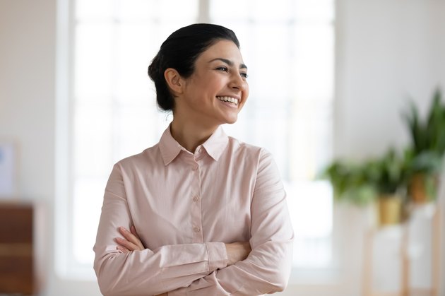 Smiling indian woman look in distance visualizing