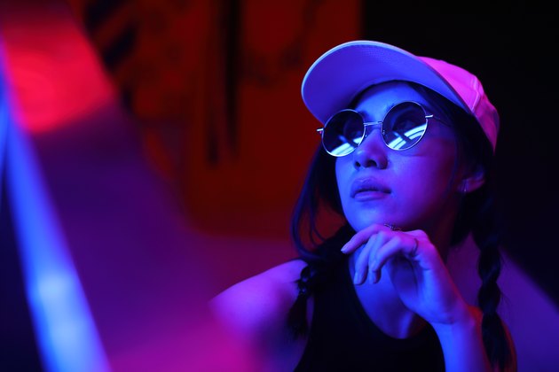 Close-Up Portrait Of Young Woman Wearing Sunglasses In Darkroom