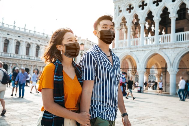 Asian couple traveling in Italy with protective face masks