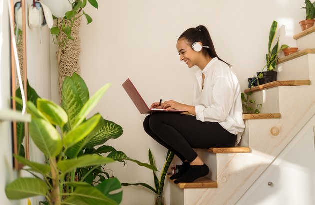 Happy young latin woman enjoying studying remotely from home