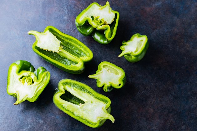 Ugly bell pepper on dark background. Sliced bell pepper halves on the table. Concept - reduction of food organic waste. Non GMO vegetables. Copy space. Top view