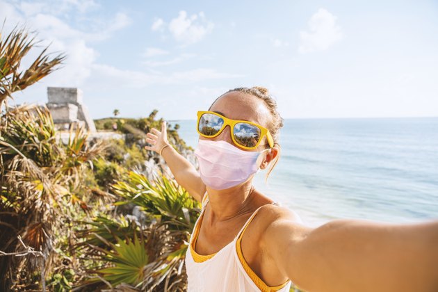 Young woman takes selfie portrait in Tulum ruins, Mexico