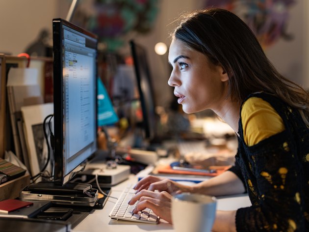 Female programmer staring at computer monitor while working in the office.