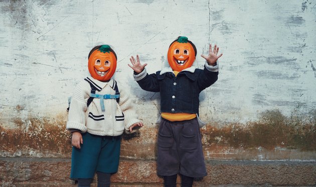 Portrait Of Smiling Boy Standing Against Wall During Halloween
