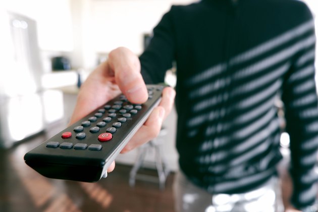 Man Points Remote Control at TV